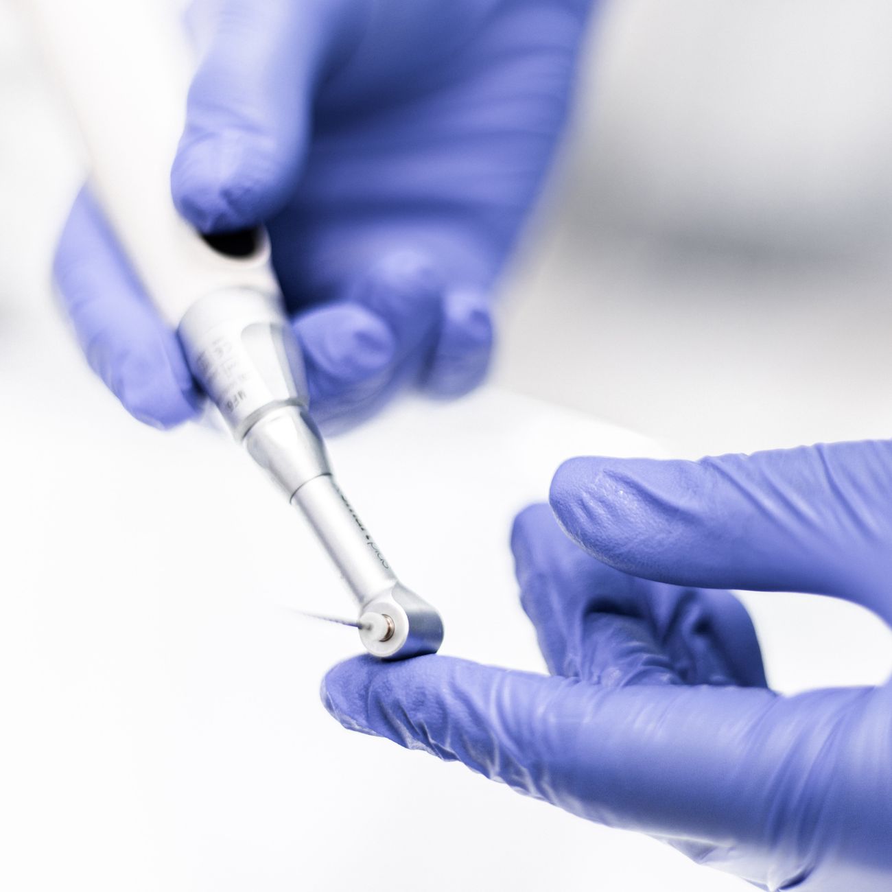 Tandlægen i detaljeret arbejde med instrument